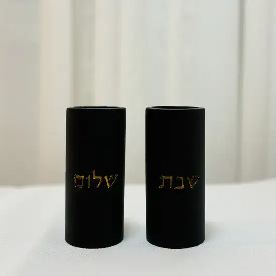 פמוטי בטון מעוצבים, בשילוב כיתוב מוזהב "שבת שלום".